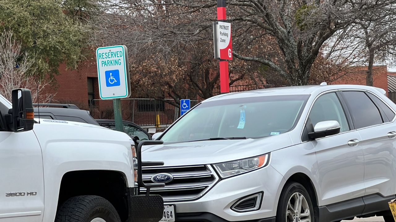 The International Symbol of Access on a sign and a Disabled Parking Placard in a car outside Dallas VA Hospital. (Spectrum News 1/Stacy Rickard)